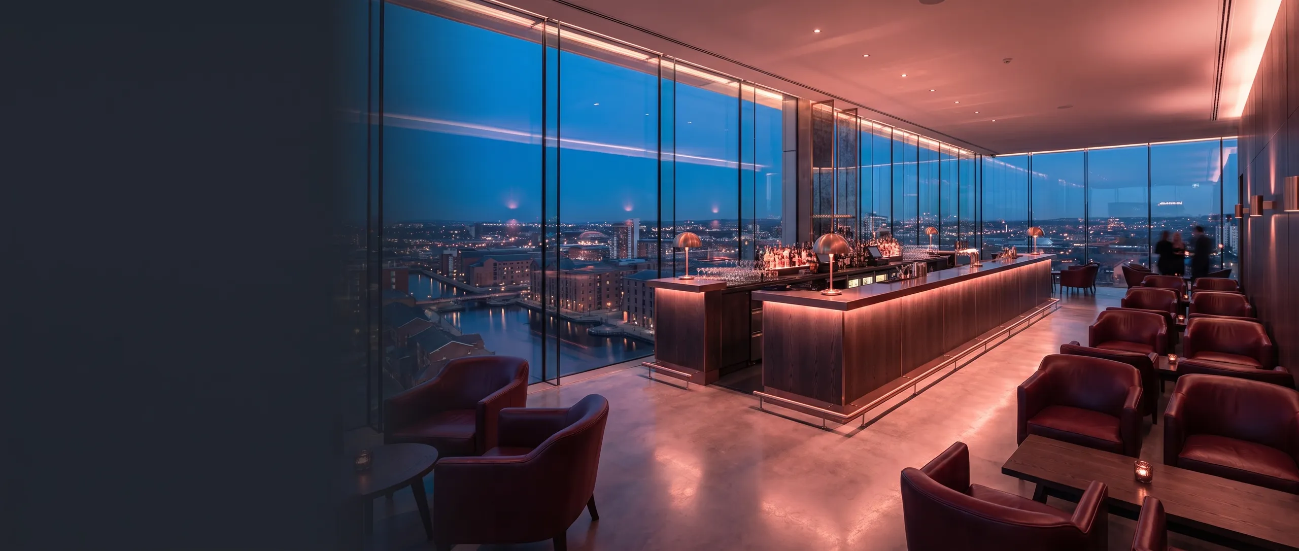 Level 41: a long backlit oak bar and oxblood armchairs behind glass, the city lights far below